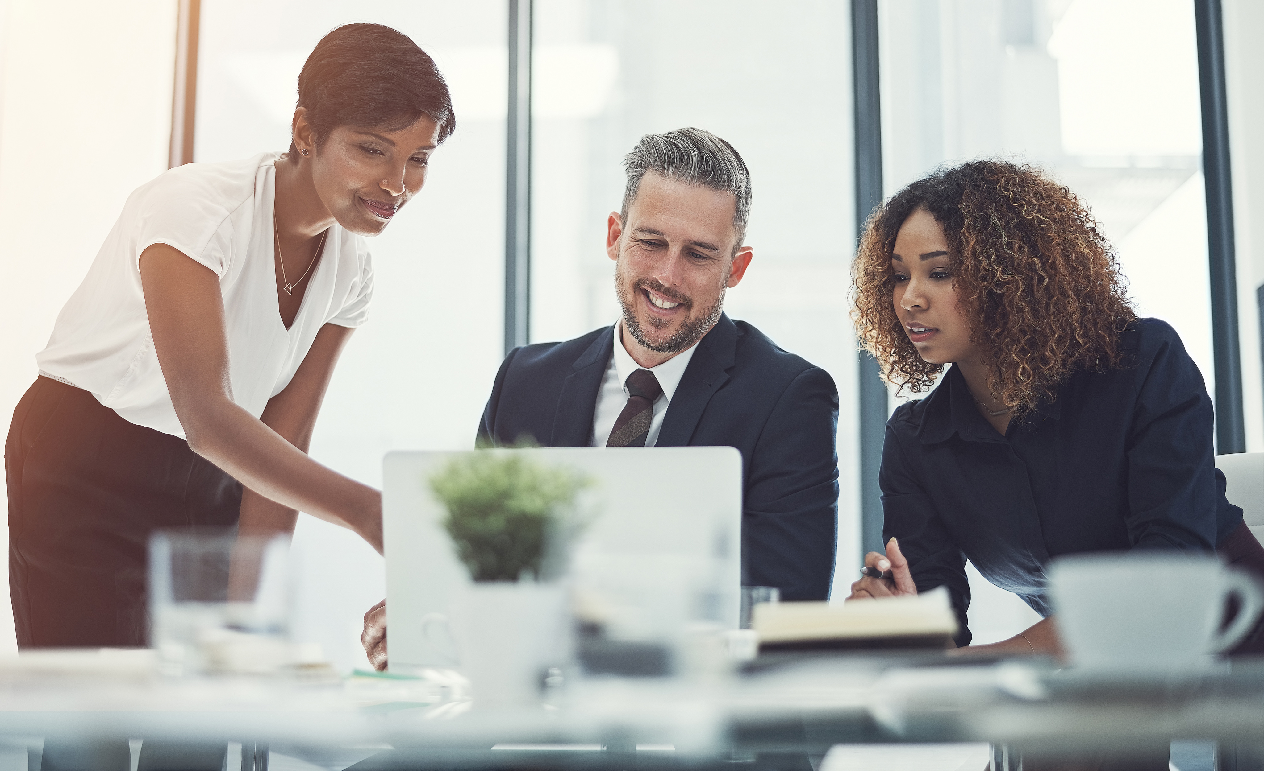 Team of consultants reviewing AI governance framework on laptop